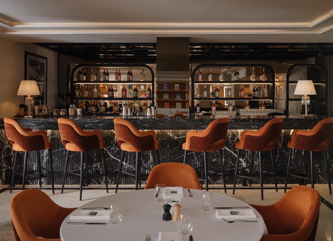 Le Bar, comptoir de marbre noir et tabourets terracotta